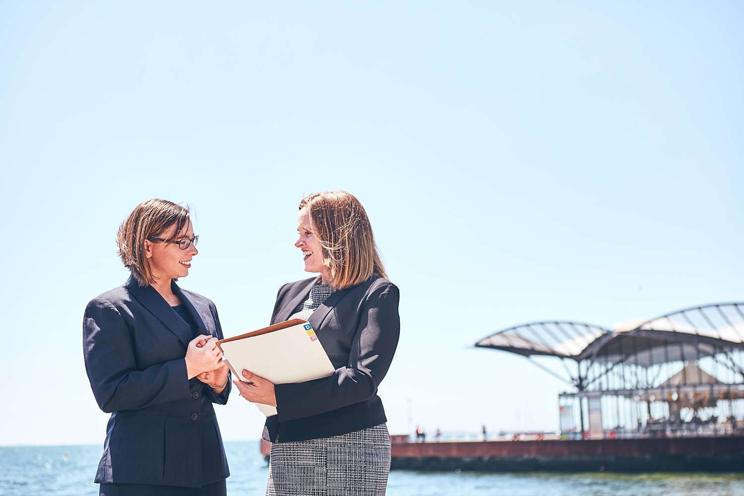 Allison Murphy and Alicia Carroll holding files, along Geelong waterfront