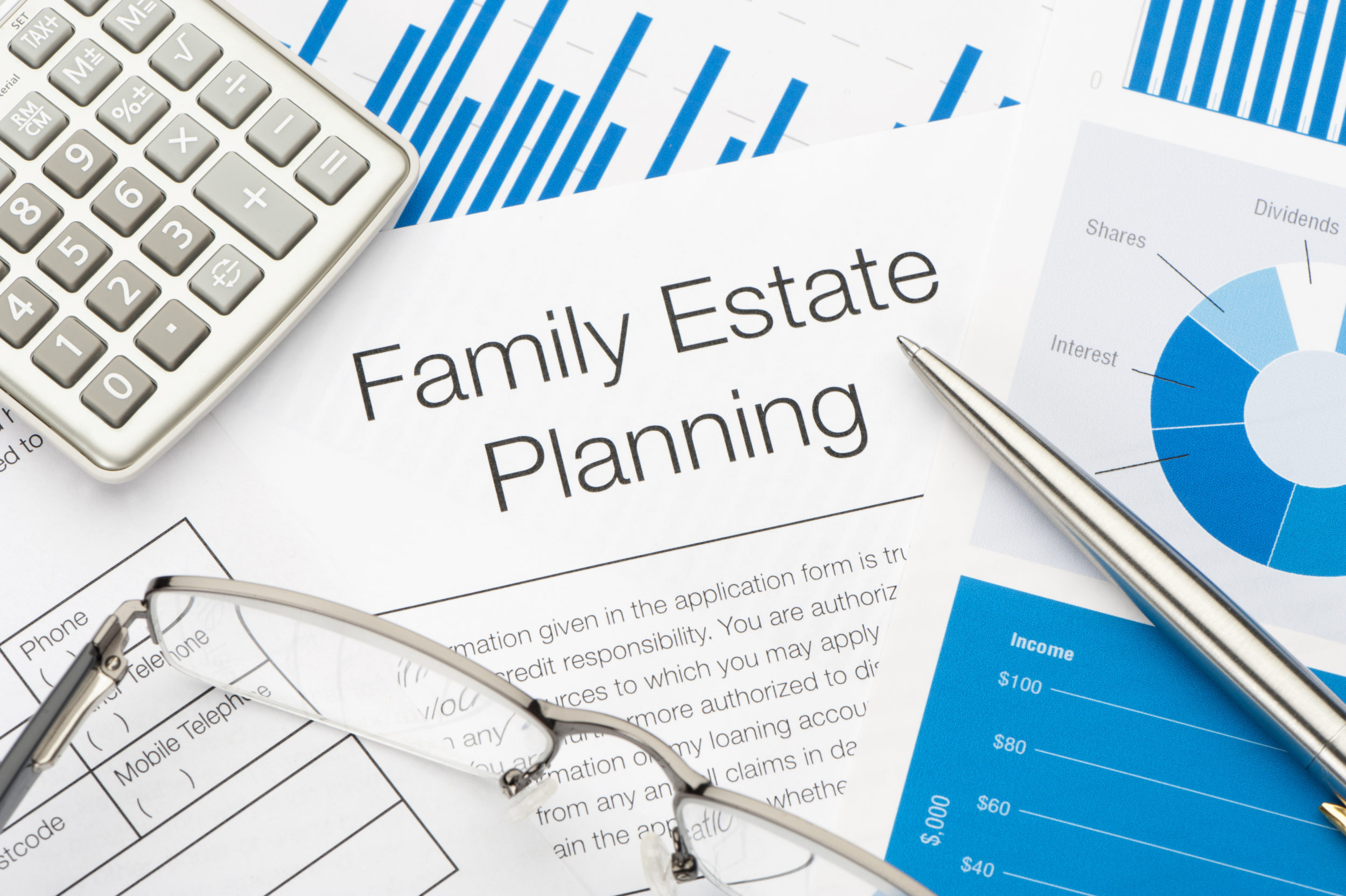 Documents showing Family Estate Planning, with calculator, silver pen and glasses